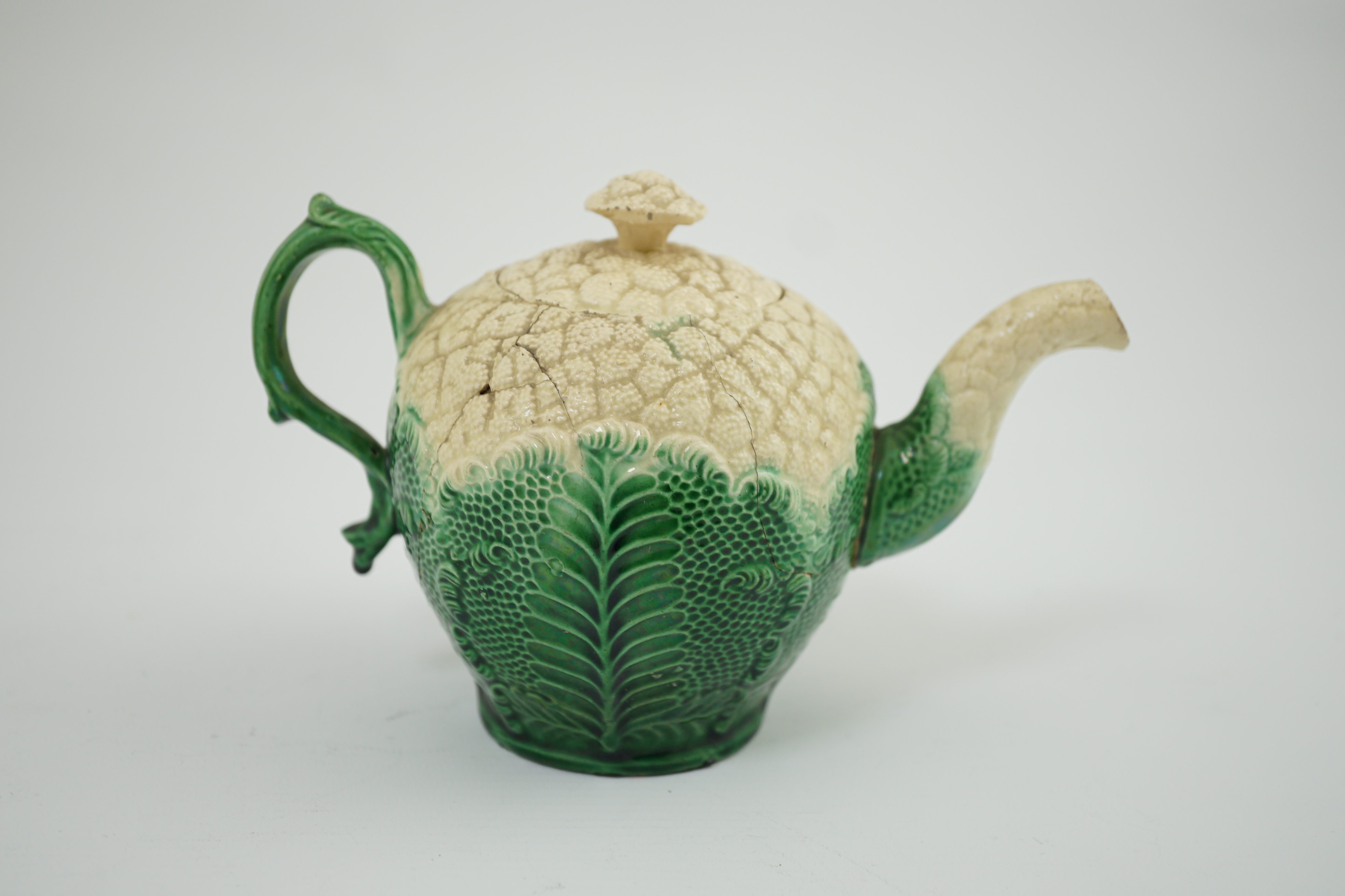 A Staffordshire cauliflower shaped creamware teapot and cover, c.1770, 10. 5 cm high. Condition - broken and repaired